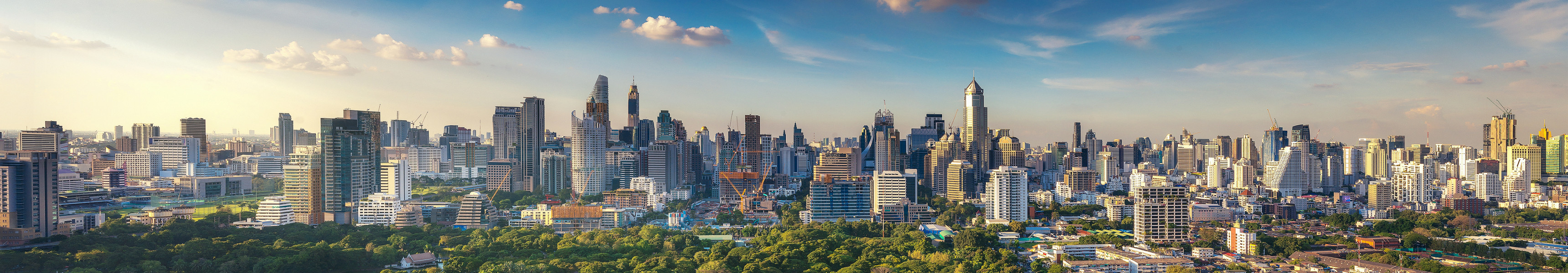 Blick von der Dachterrasse eines Hotels auf den Lumpini-Park und die Skyline von Bangkok