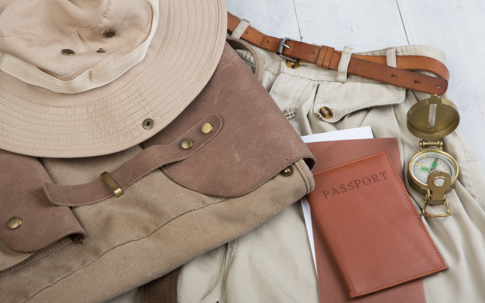 Safari-Ausr&uuml;stung: Hut, Rucksack, Kompass und Reisepass f&uuml;r Abenteuer in Afrika.