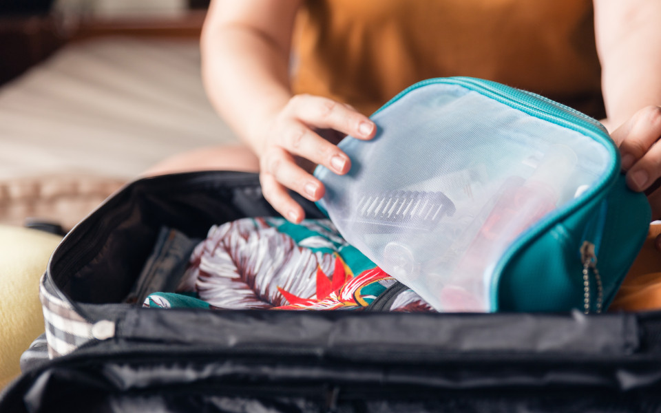 Frau verpackt Ihre Kleidung in unterschiedliche Beutel f&uuml;r den Urlaub 