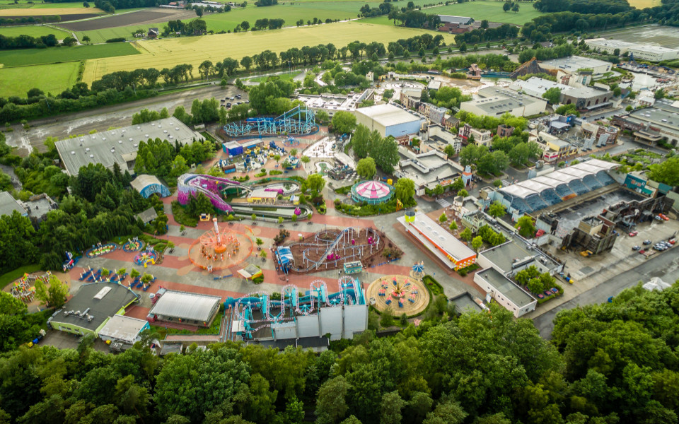 Luftaufnahme des Movie Parks in Bottrop, der verschiedene Fahrgeschäfte, bunte Attraktionen und ein weitläufiges Gelände zeigt.